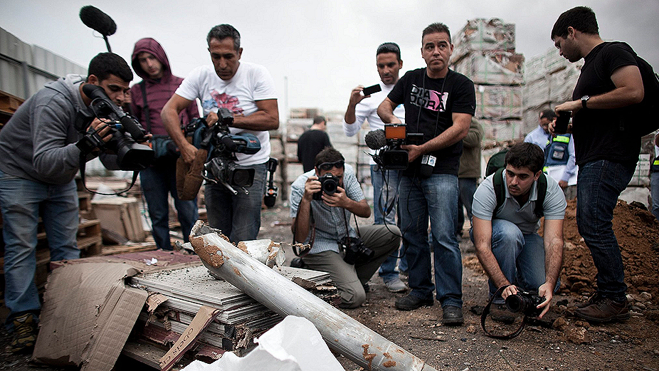Journalists covering the war in Afghanistan taking photos of bomb damage